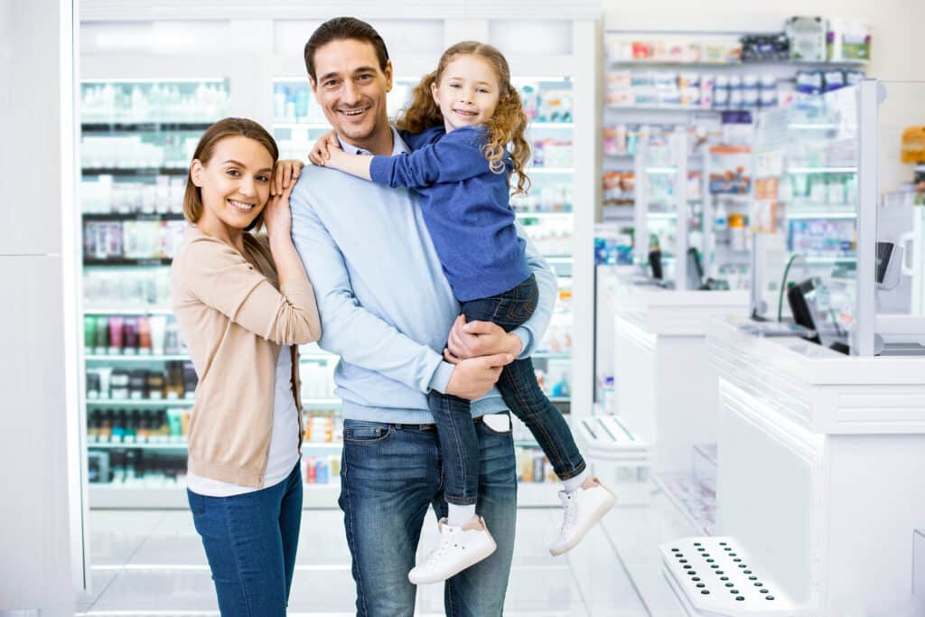 Family smiling together in a pharmacy.
