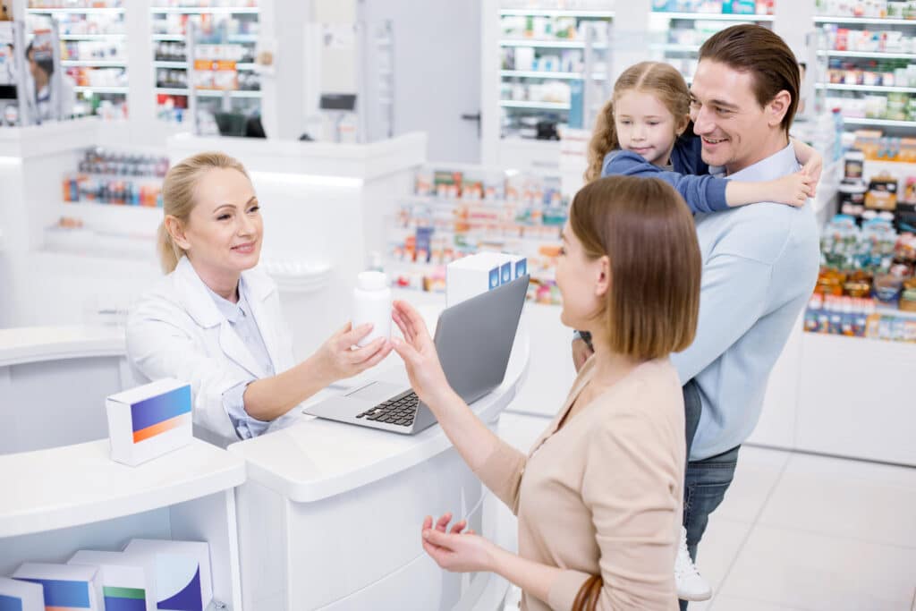 Pharmacist handing medicine to a family.
