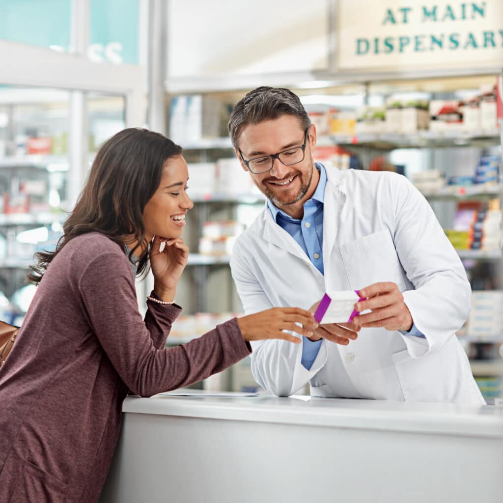 Pharmacist assisting customer with prescription information.