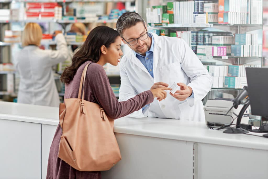 Pharmacist assists customer with medication information.