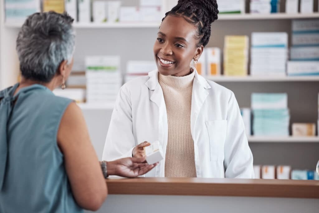 Pharmacist assisting customer at pharmacy counter.