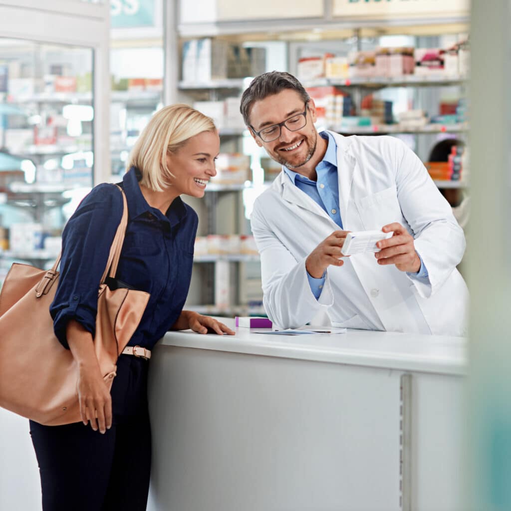 Pharmacist explaining medication to customer at pharmacy.